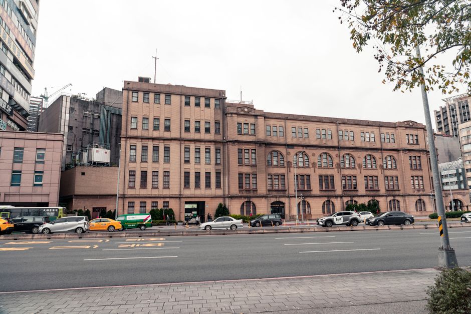 Street view of a historic building facade in Taipei City, Taiwan with traffic in front.
