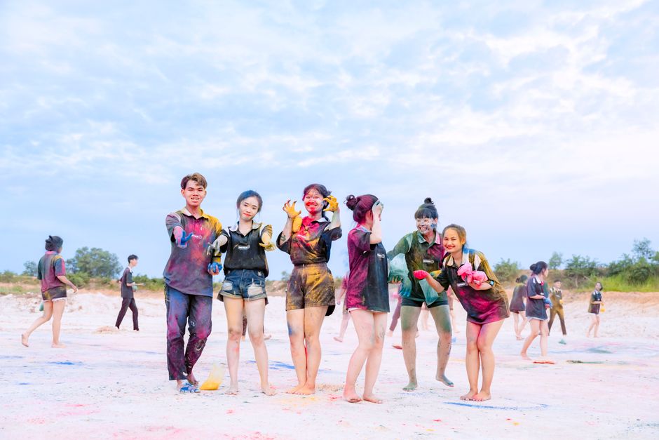 Friends playfully celebrating with colorful powder, enjoying a fun day outdoors.